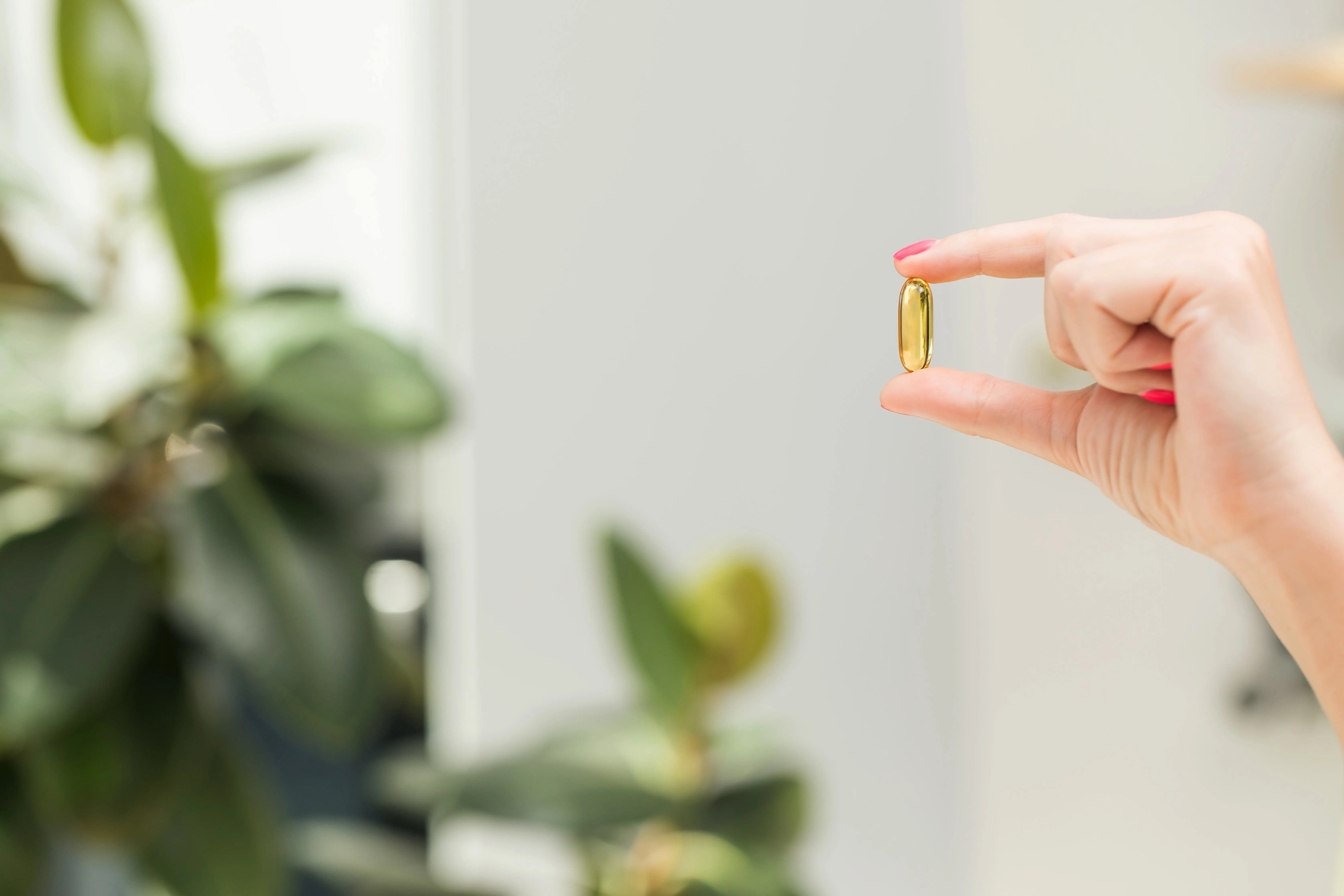 Woman Holds Her Hand Yellow Transparent Capsule With Vitamin D Omega 3 Close Up